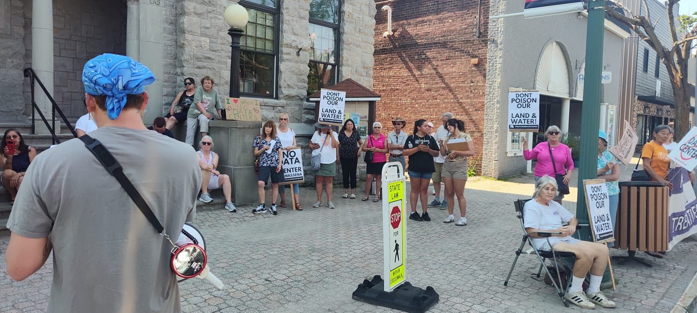 Residents gathered with signs outside Massena Town Hall at the June 29 rally