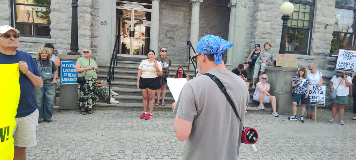 A speaker reads a statement to the crowd on the Town Hall steps